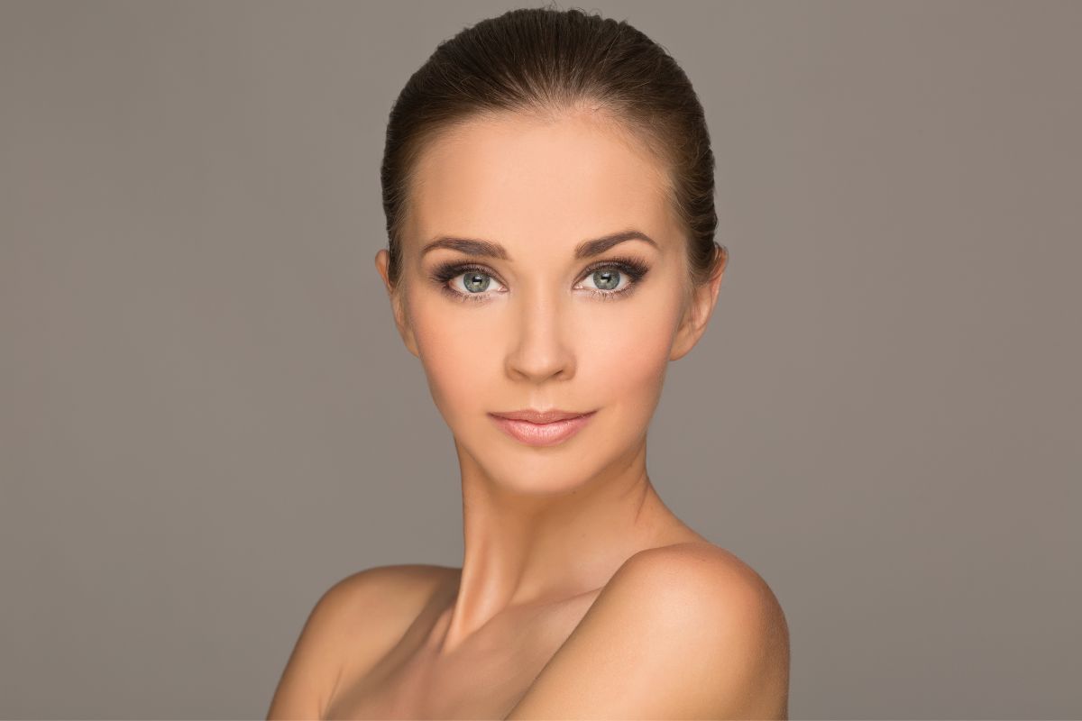 Mujer con piel tersa y rostro armonizado en un entorno estético profesional.