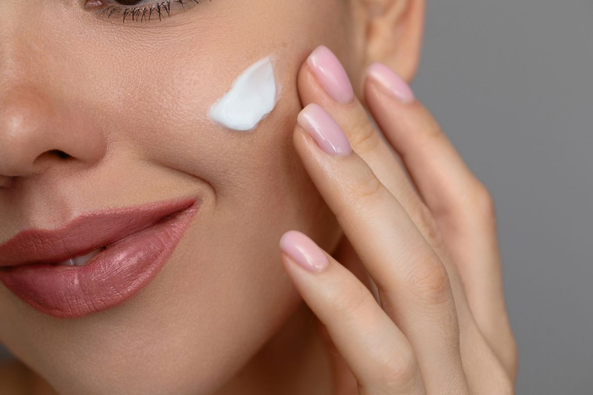 Mujer madura tocando suavemente su rostro con una expresión natural que refleja el cuidado preventivo de la piel y el envejecimiento facial.