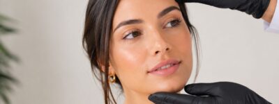 Especialista realizando una valoración de armonización facial para analizar las proporciones, simetría y equilibrio estético del rostro de una paciente.